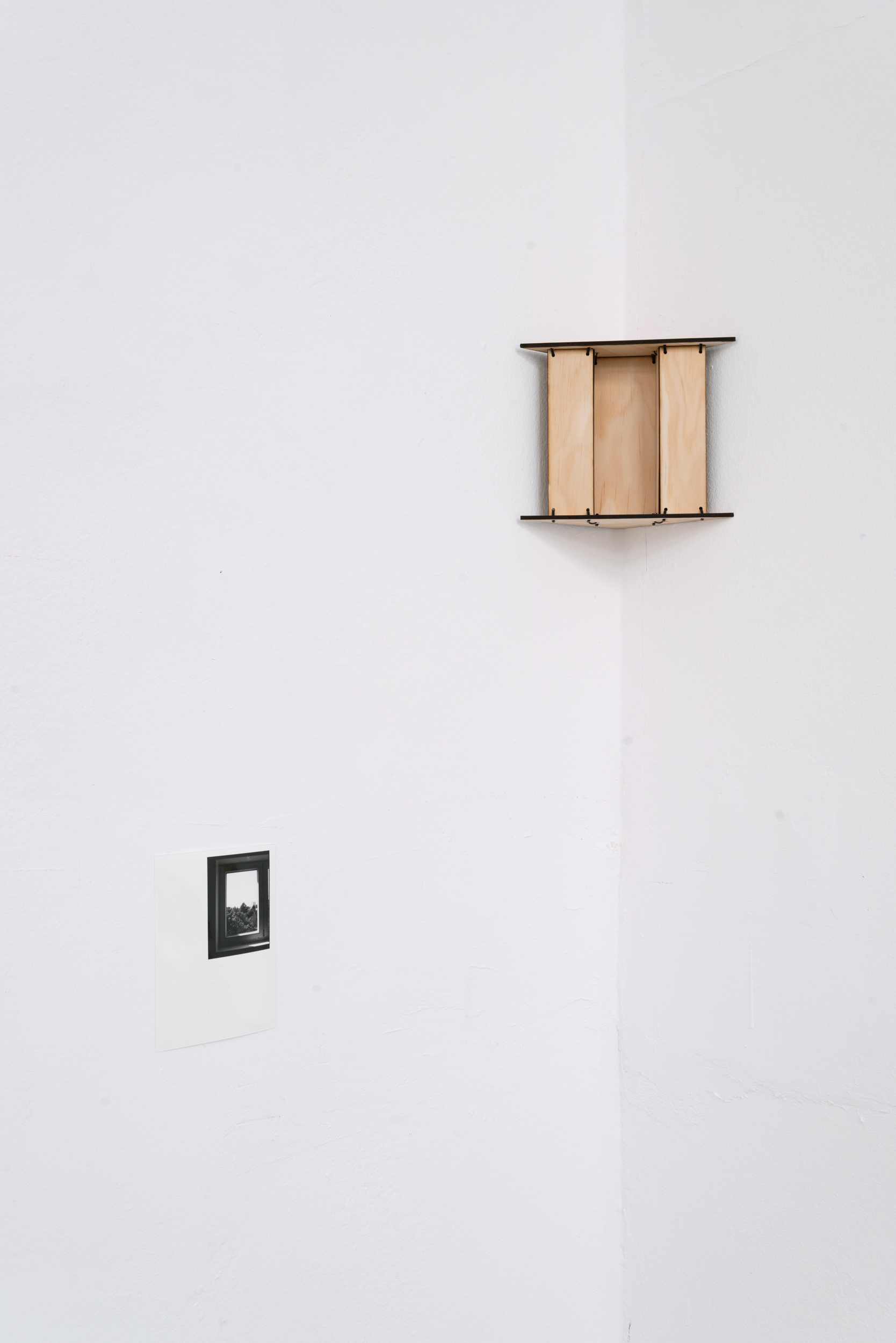 Stock für Stock, 2026 – Architekturmodell aus Kiefernsperrholz auf Wandkonsole neben einer Fotografie.